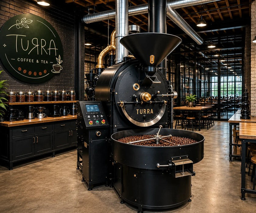 The Turra roastery floor with the drum roaster under the logo sign